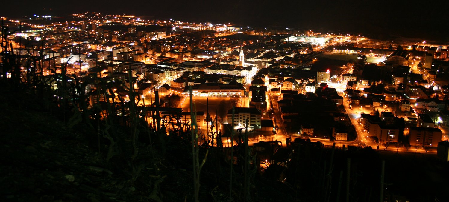 the city lit up at night with lots of lights