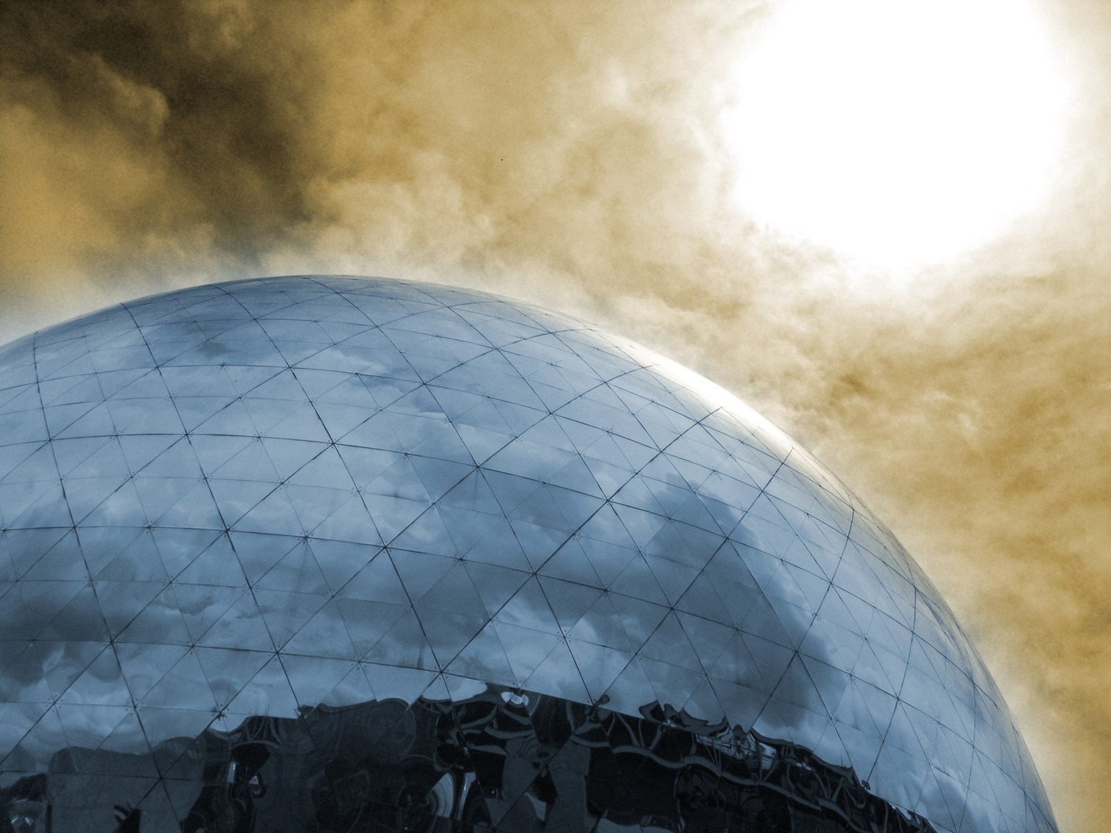 a large sphere shaped building under a cloudy sky