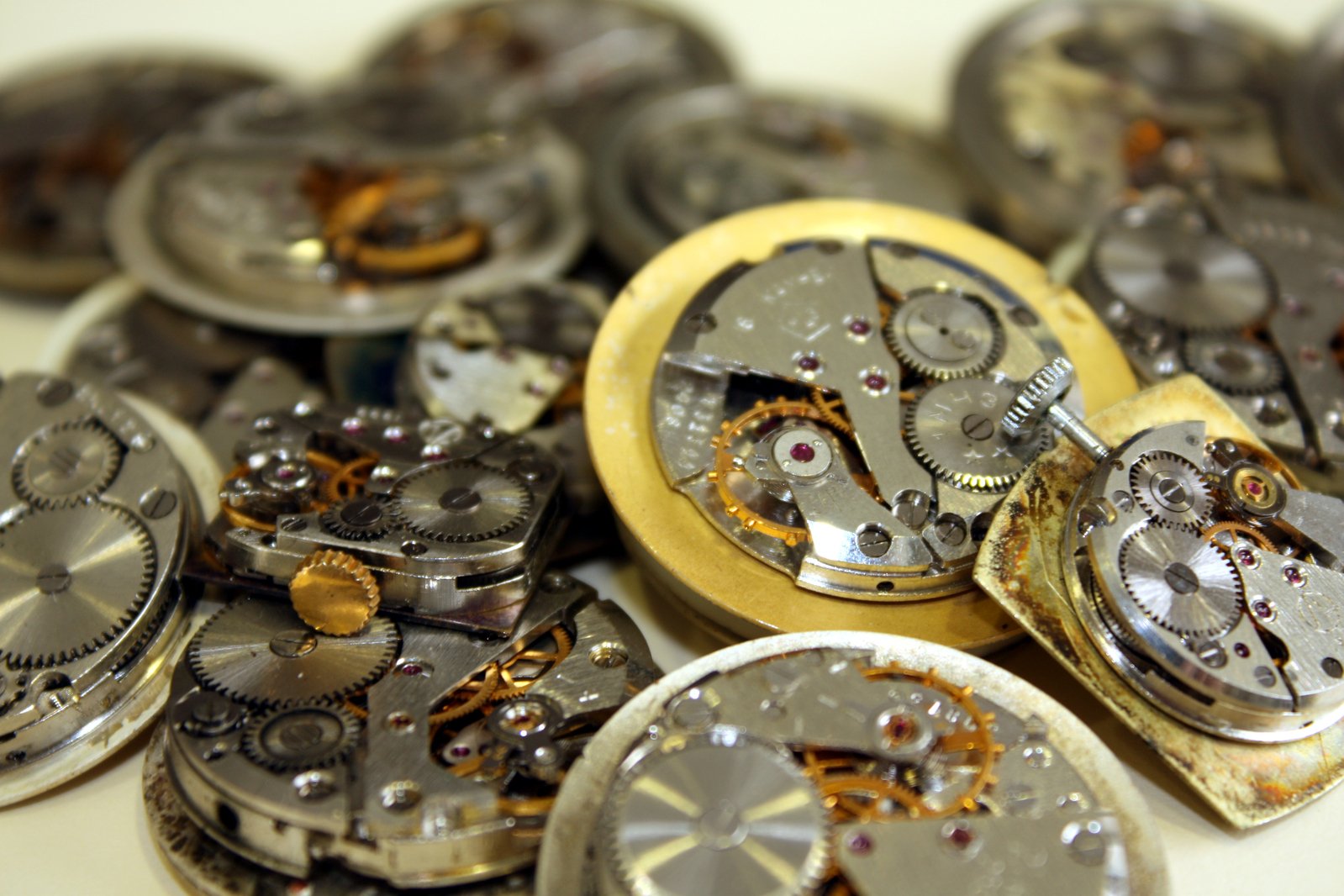 many silver watches are sitting on a table