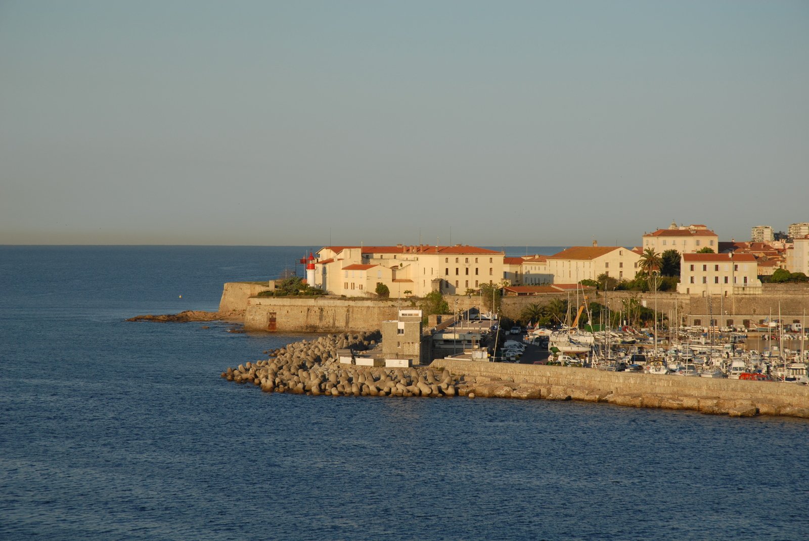 a harbor next to an old city with some boats parked along the shore