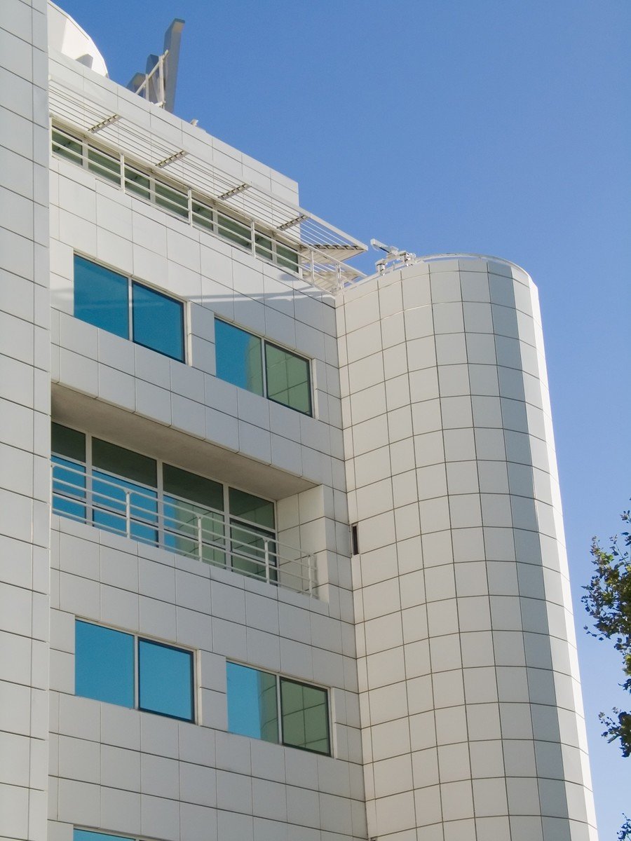 a large building with windows next to the trees