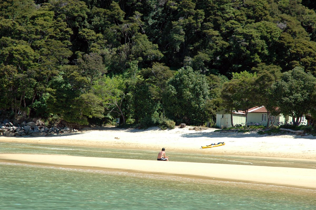 a beach on the shore line with people swimming in the water