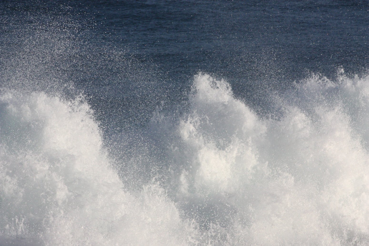 some large white waves crashing into the shore