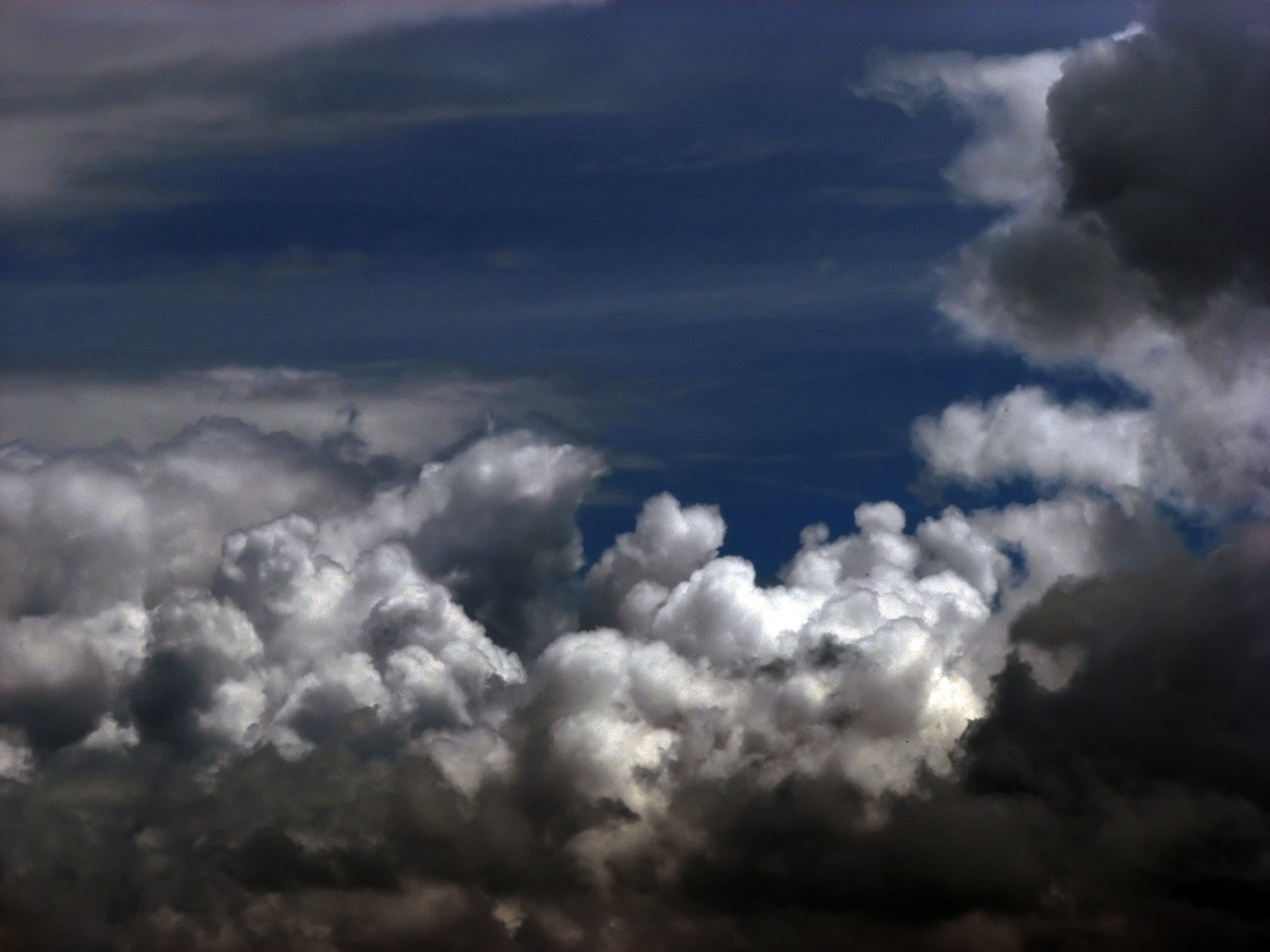 an airplane is flying in the sky above some clouds