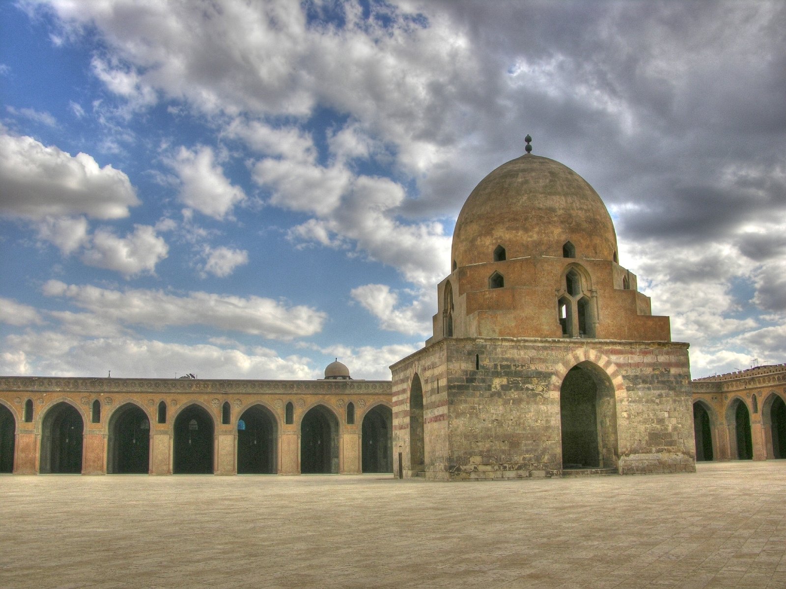 the dome on the top of a building with arches and a clock tower in it