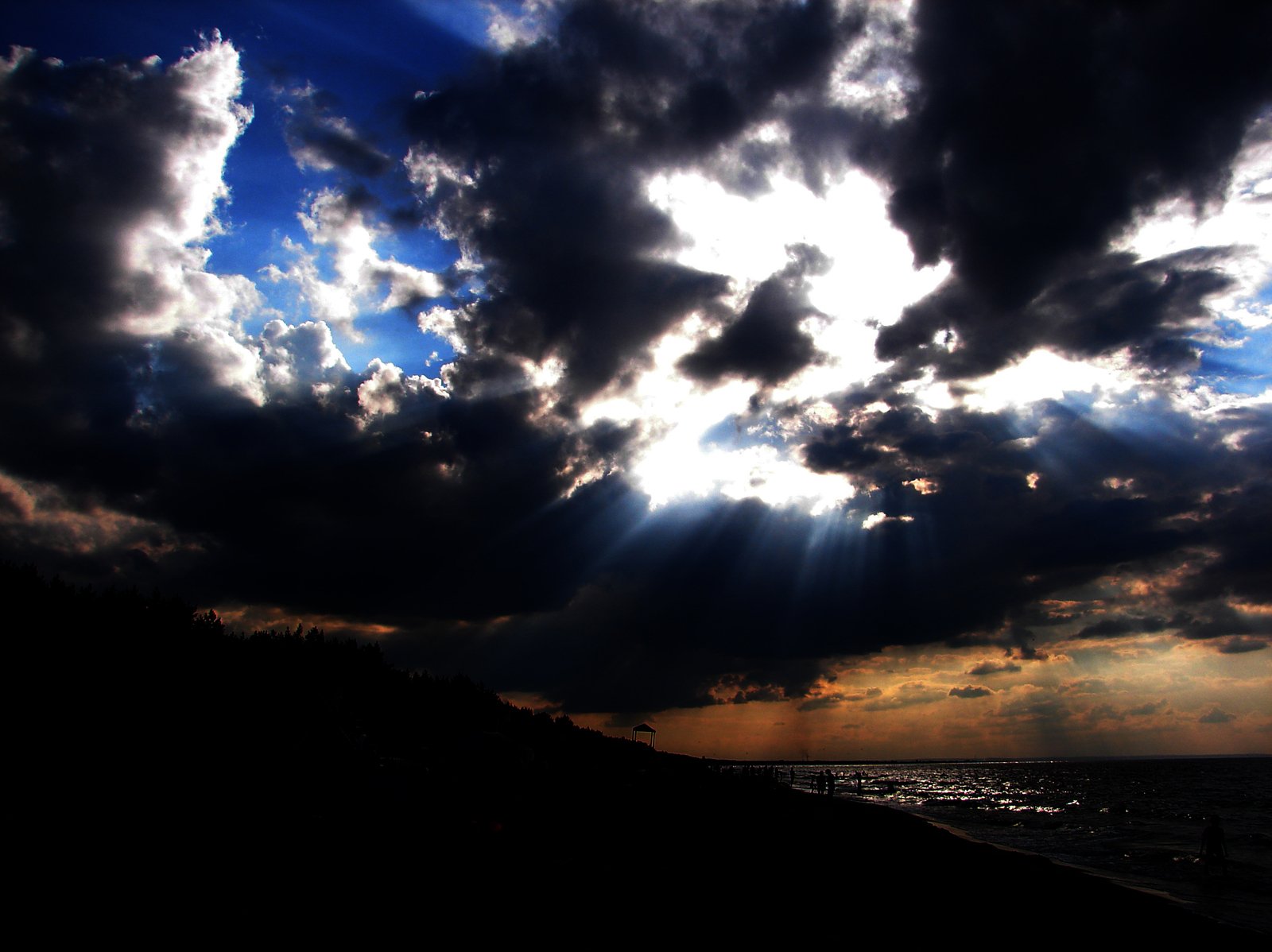 the sun beams shine through clouds above the ocean