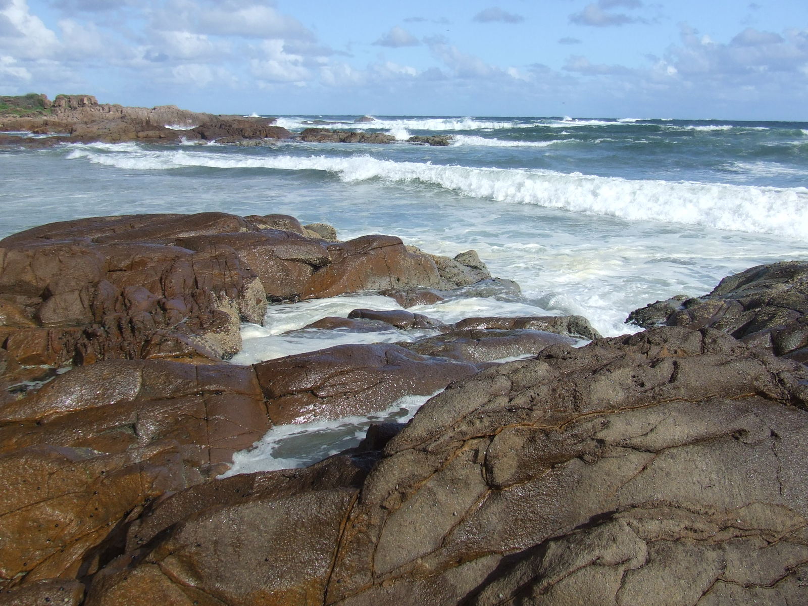 rocks on the beach are covered in water