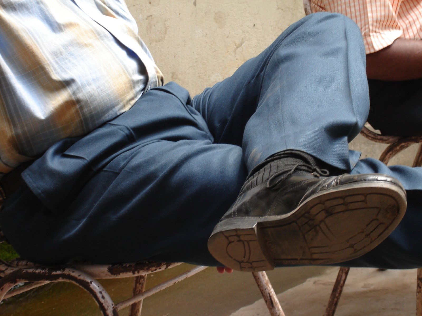 a man sitting in a chair with his feet on his lap