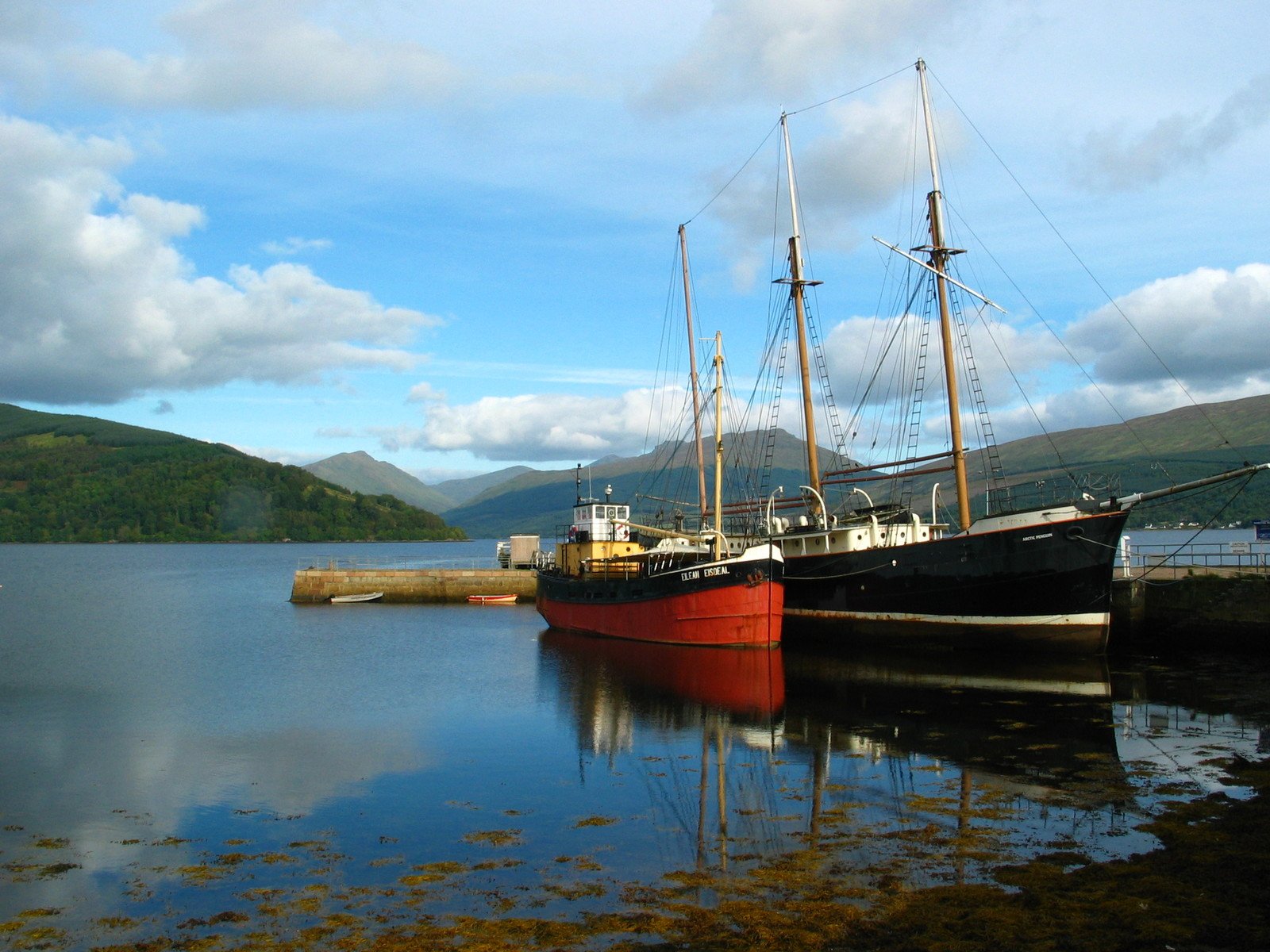 a red and black ship sitting in the water