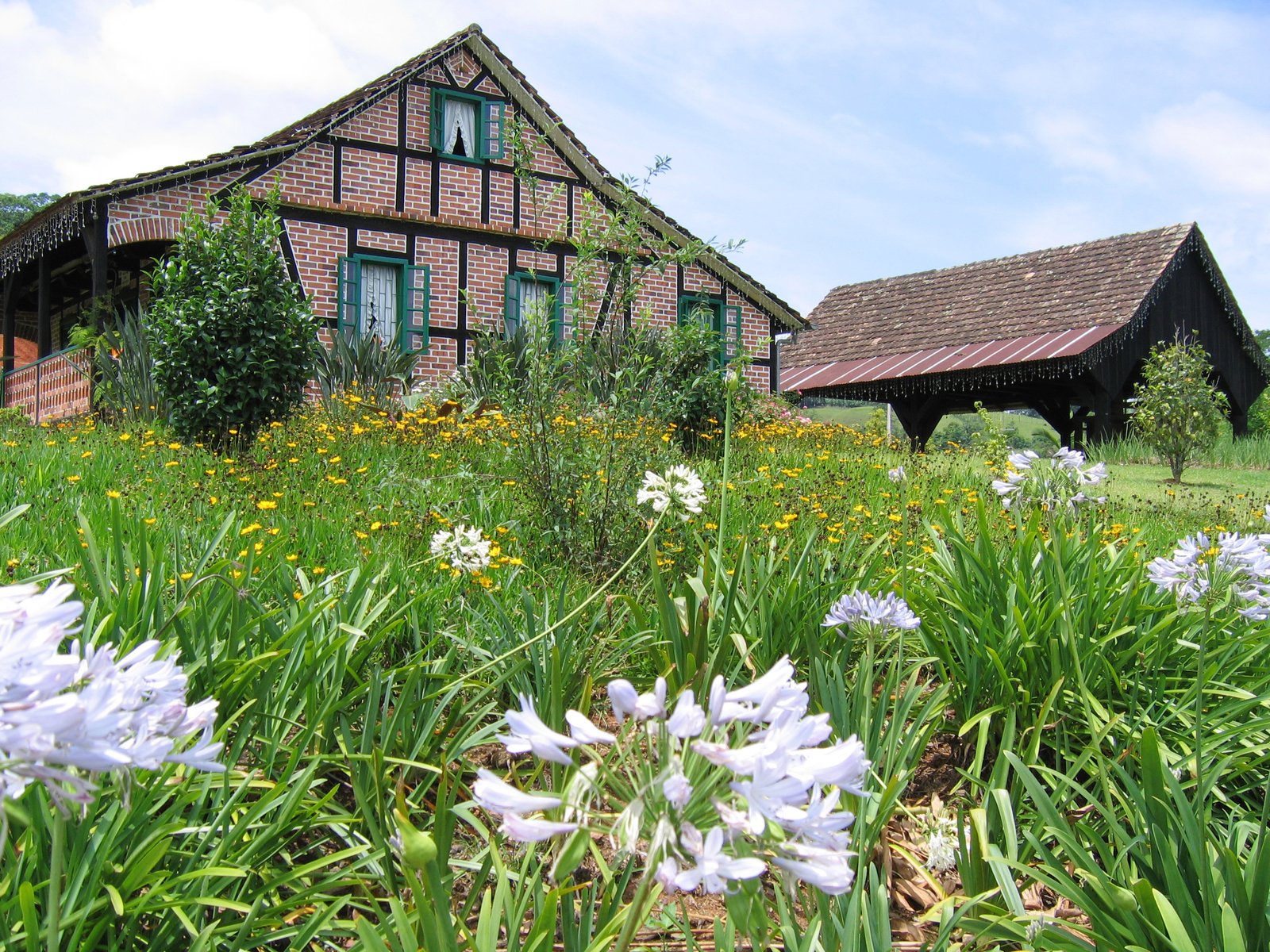 an old brick house is surrounded by flowers