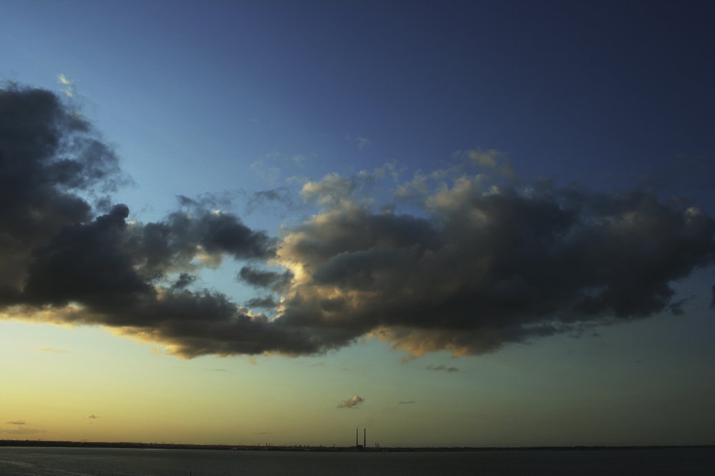 the sun rising over a large body of water