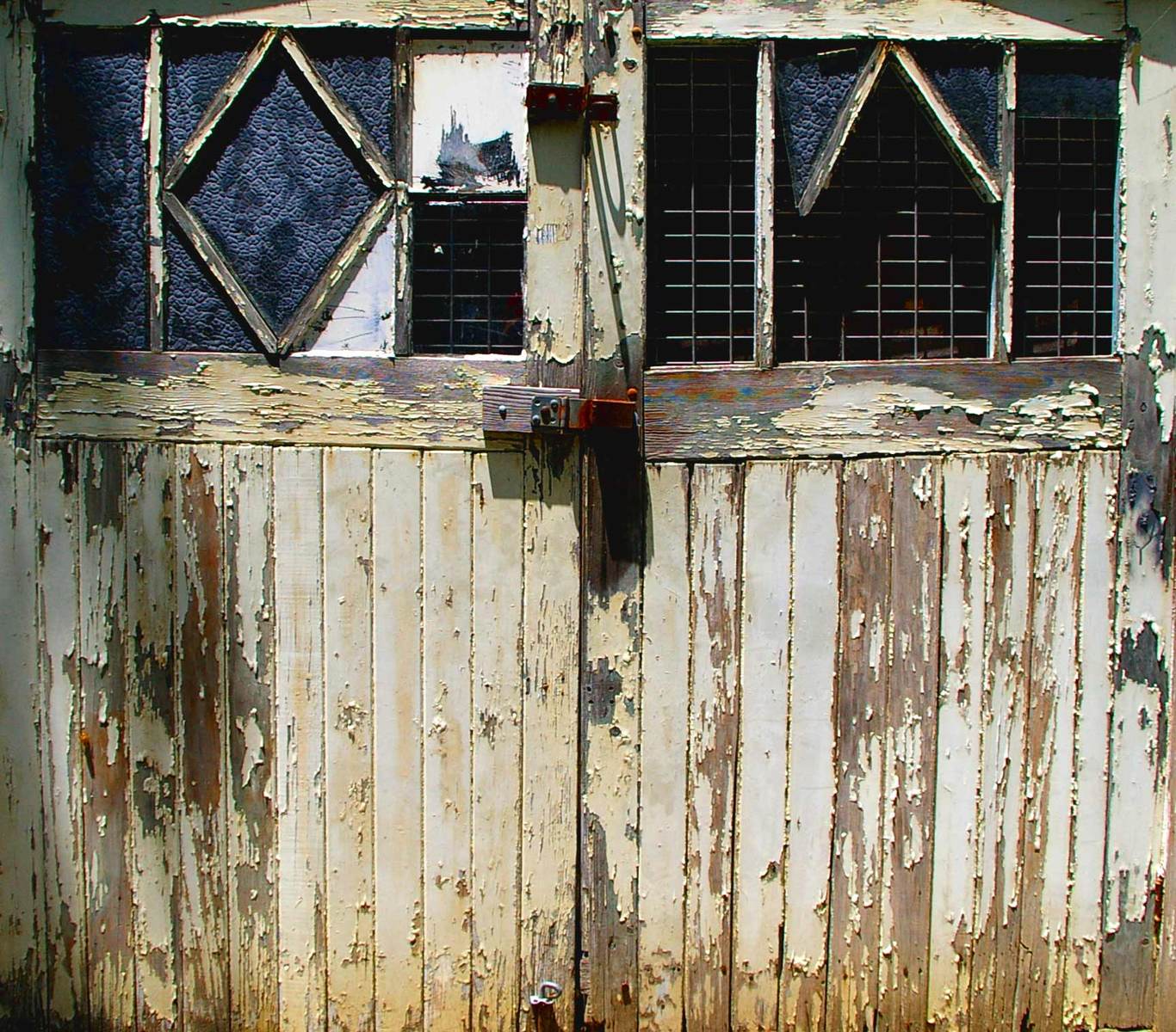 a rusty door with ed glass windows and a fire hydrant