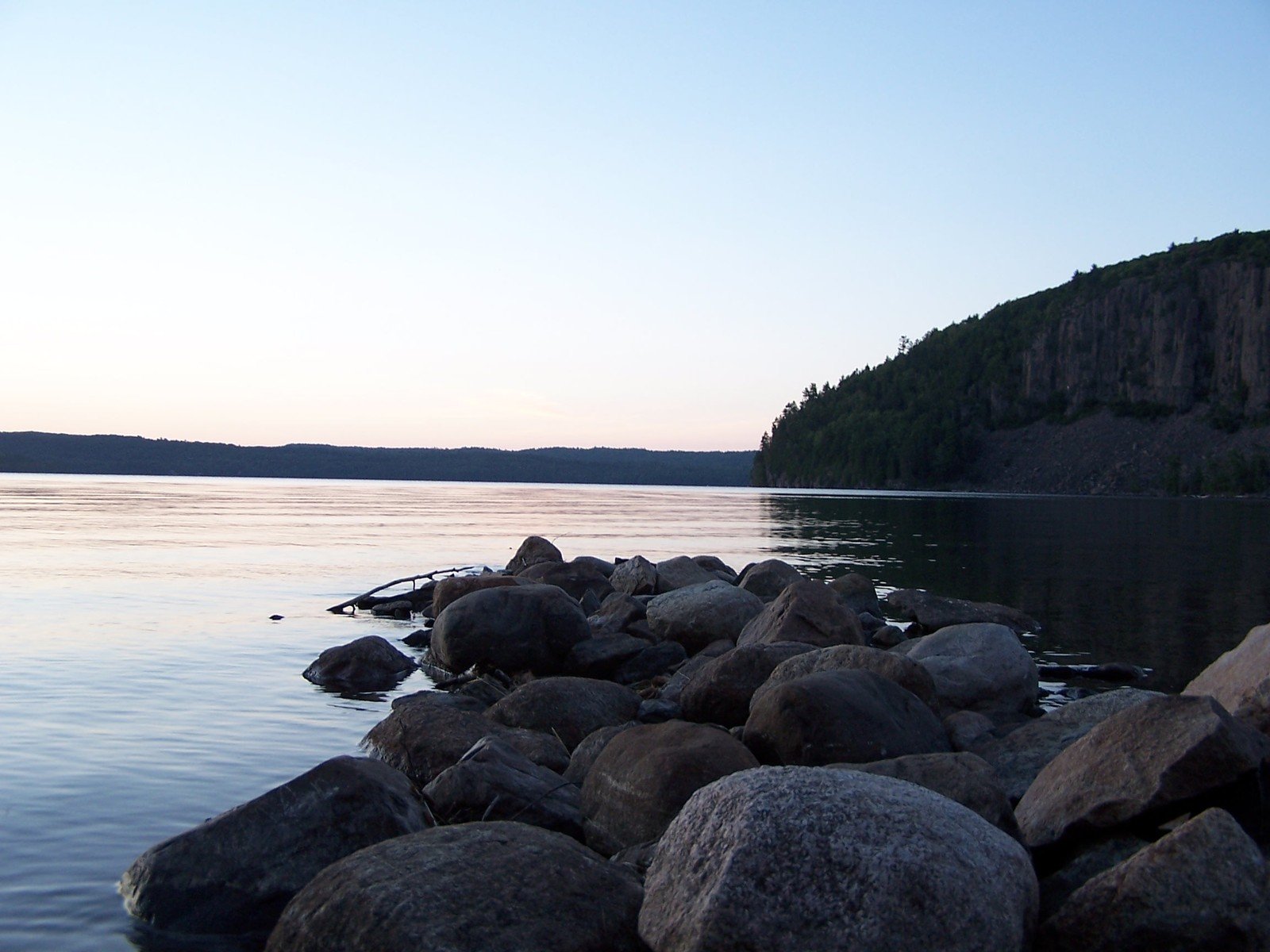 rocks and water on a shoreline in front of an island