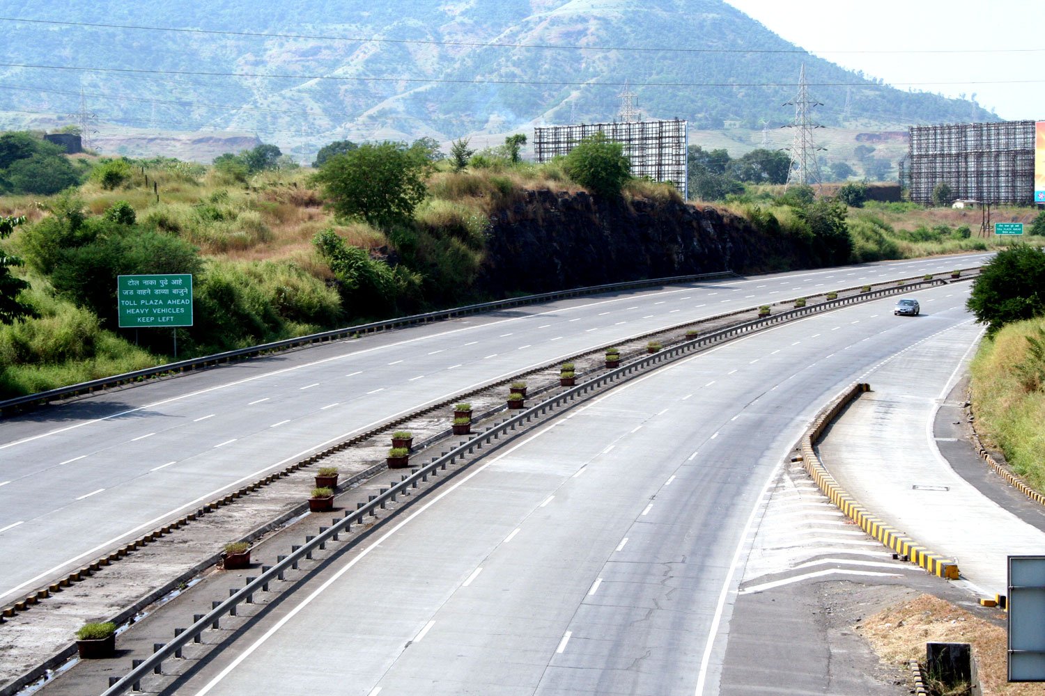 a highway with several lanes and an exit sign on one side