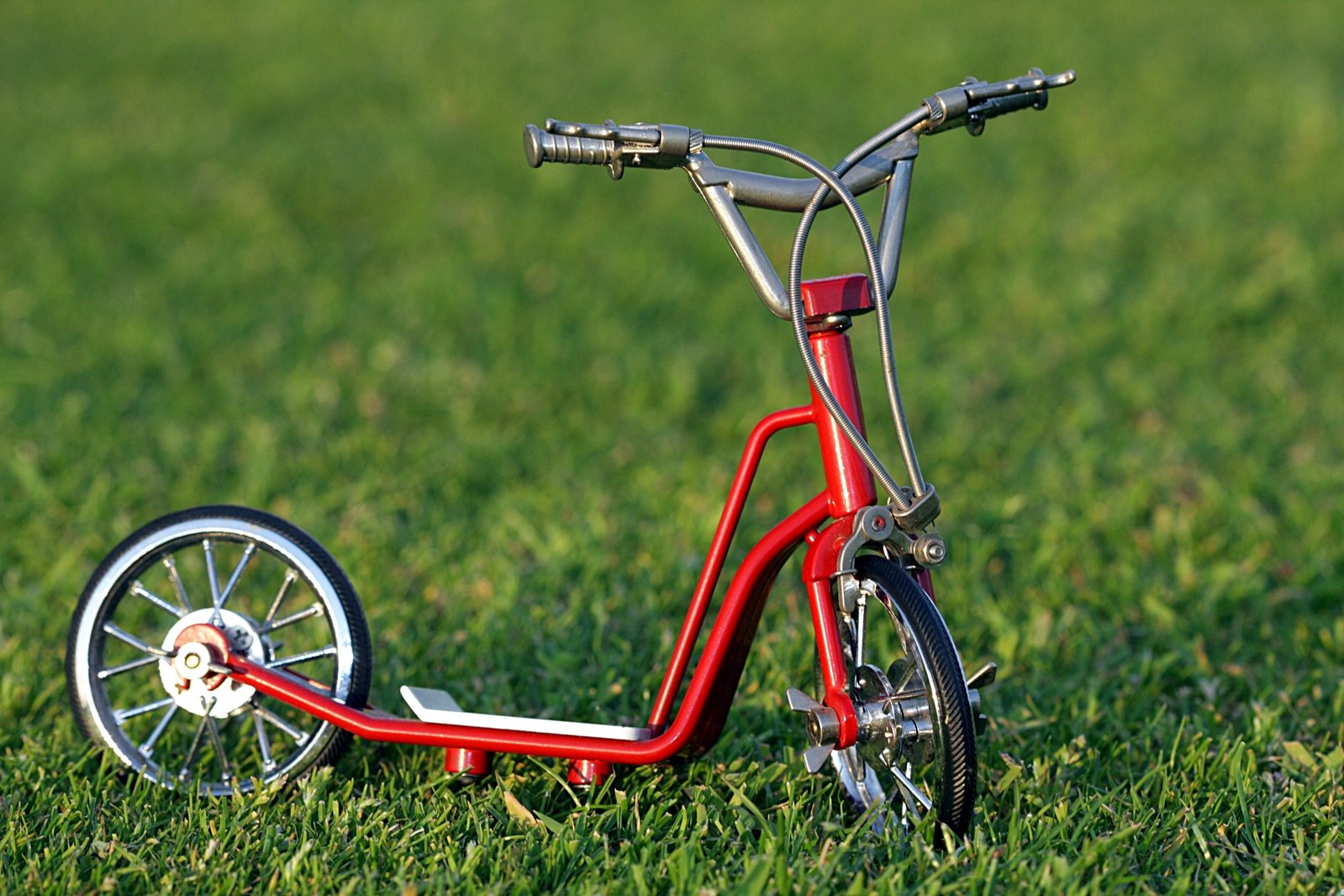 a small model bike laying in the grass