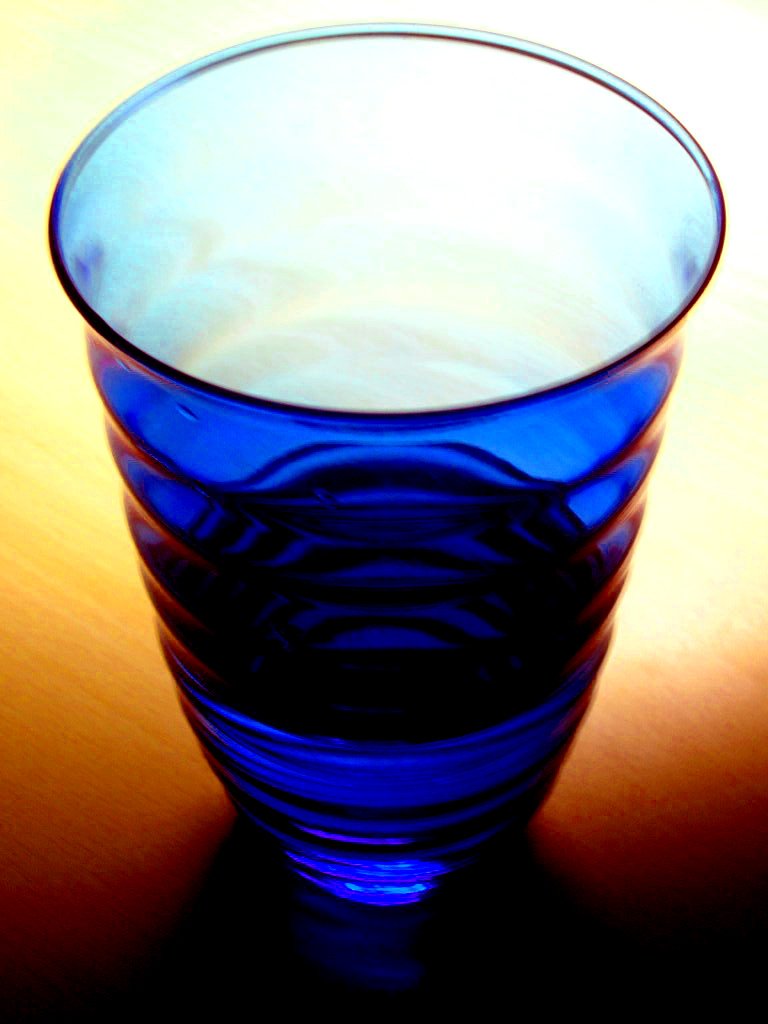an empty blue glass on a brown surface