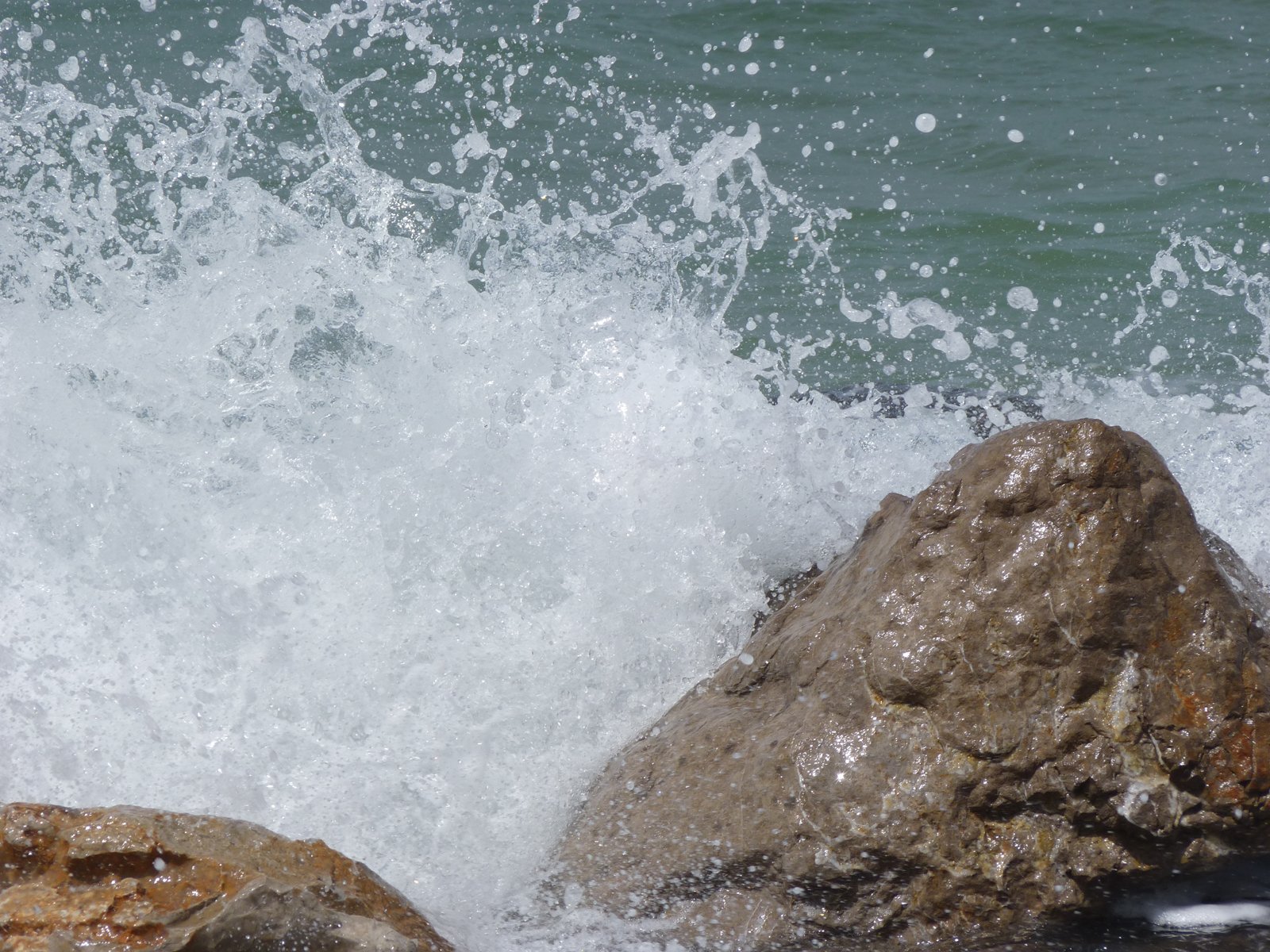 a rock with water splashing up around it