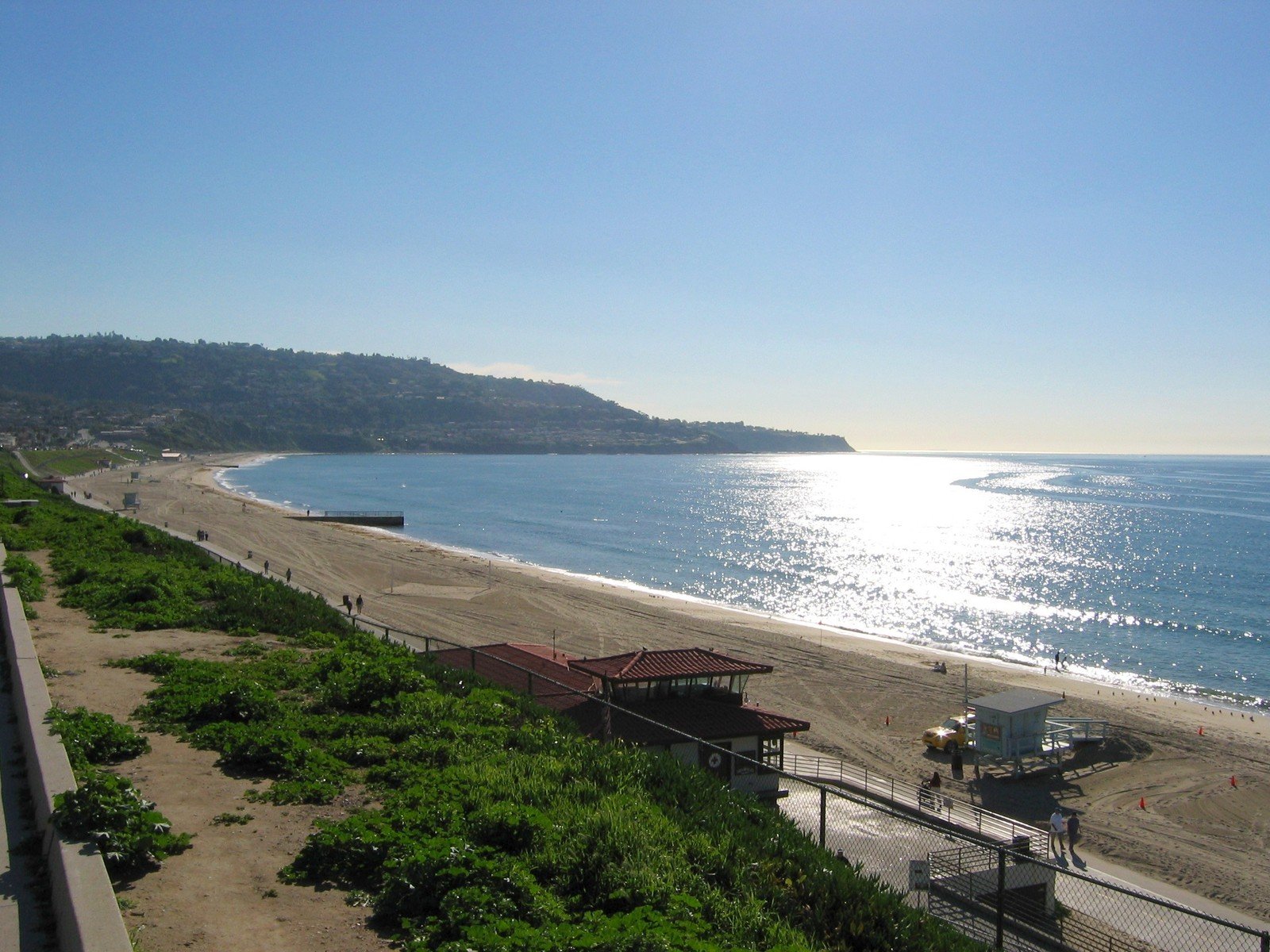 beach near ocean under sunny blue sky near shore