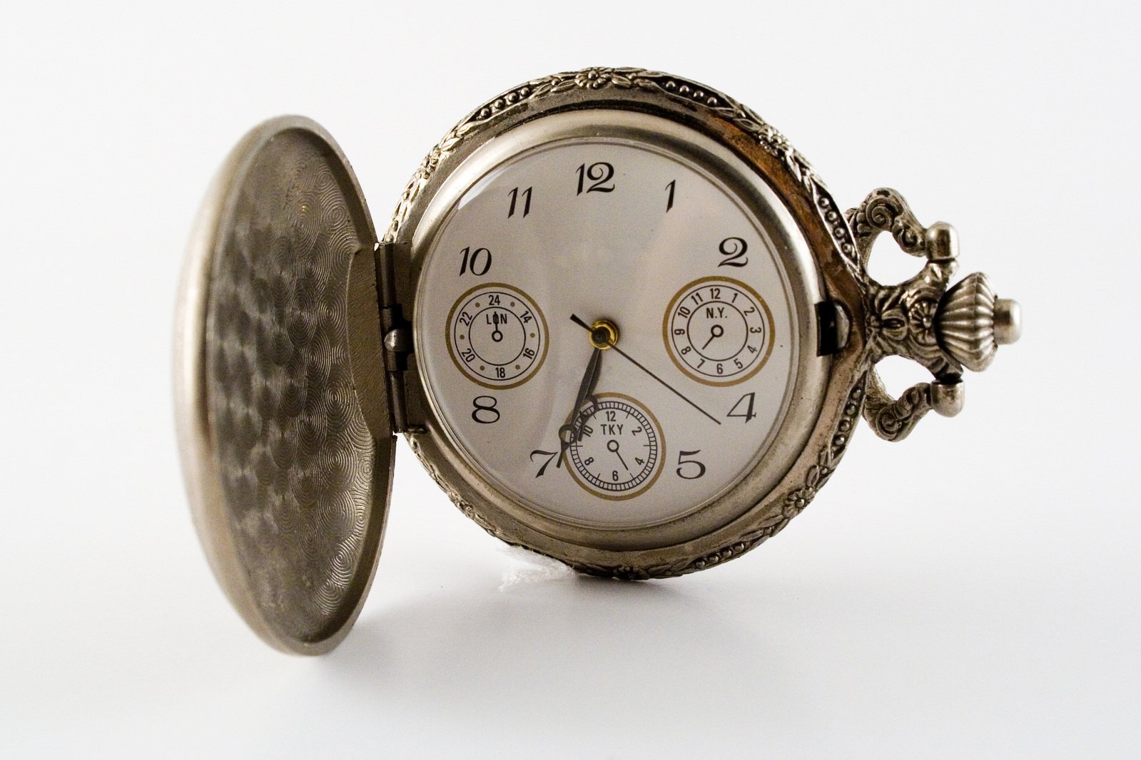 a pocket watch that is silver and brown