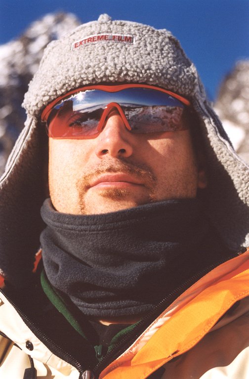 a man is bundled up in a thick coat and wearing a pair of shades