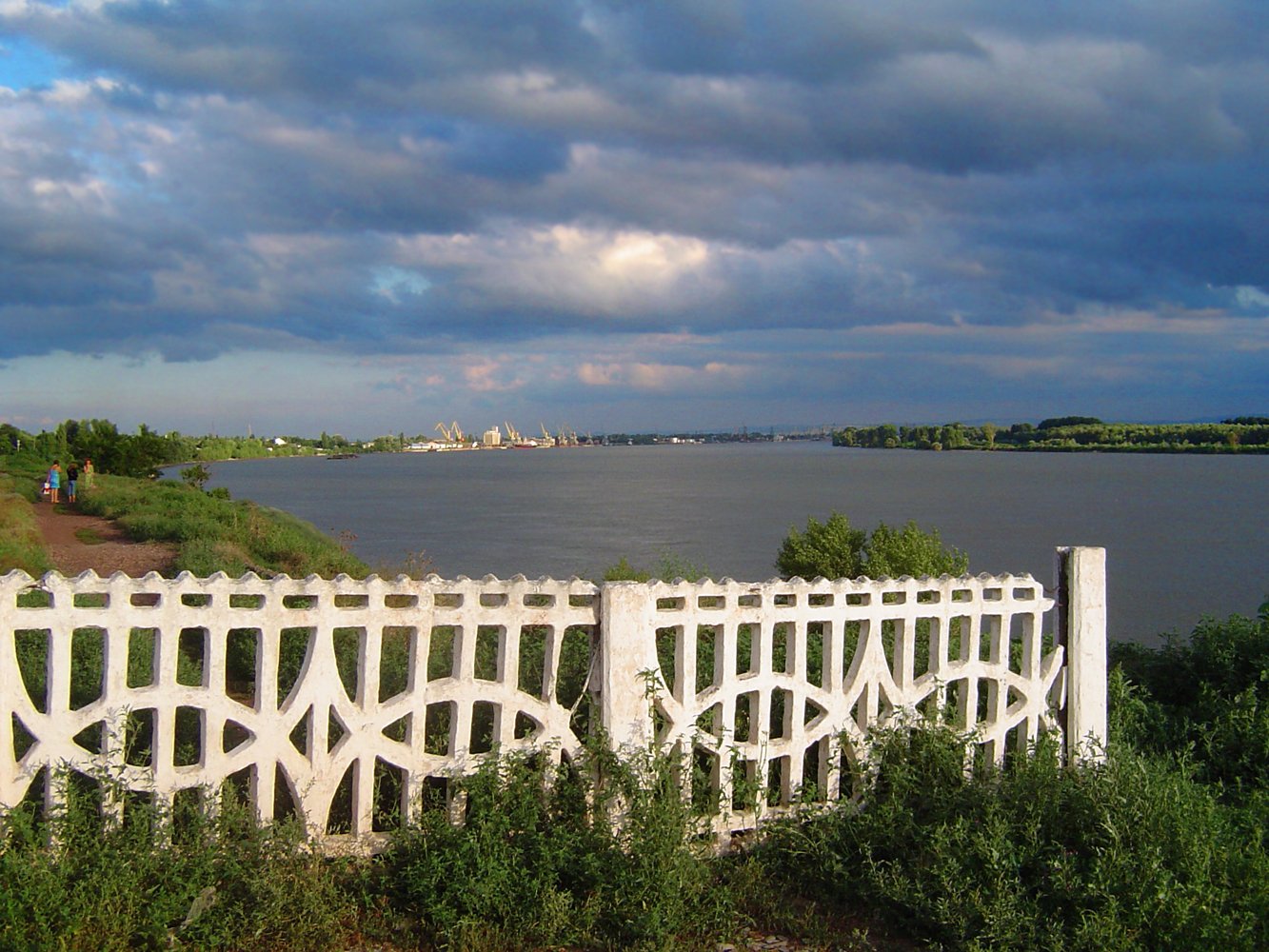 white fence and grass with water in the background