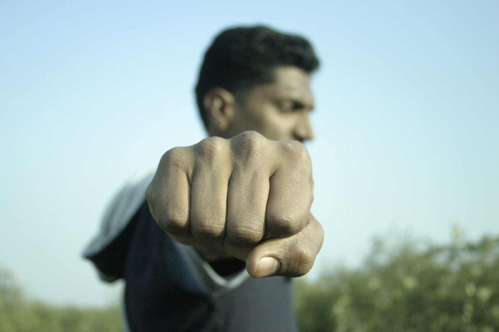 man in black jacket pointing at the camera