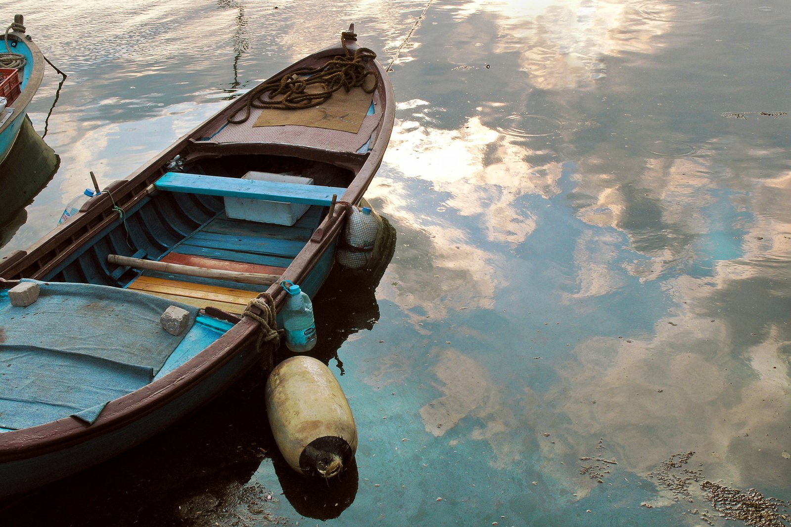 two boats sit on a wet, cloudy lake