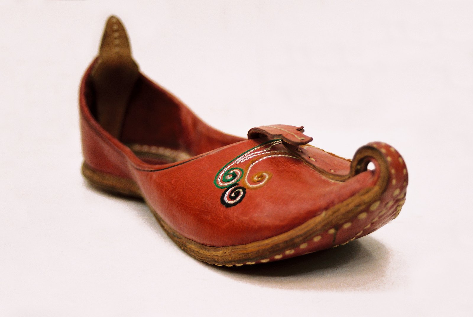 an orange women's shoe with beading and wooden heeling