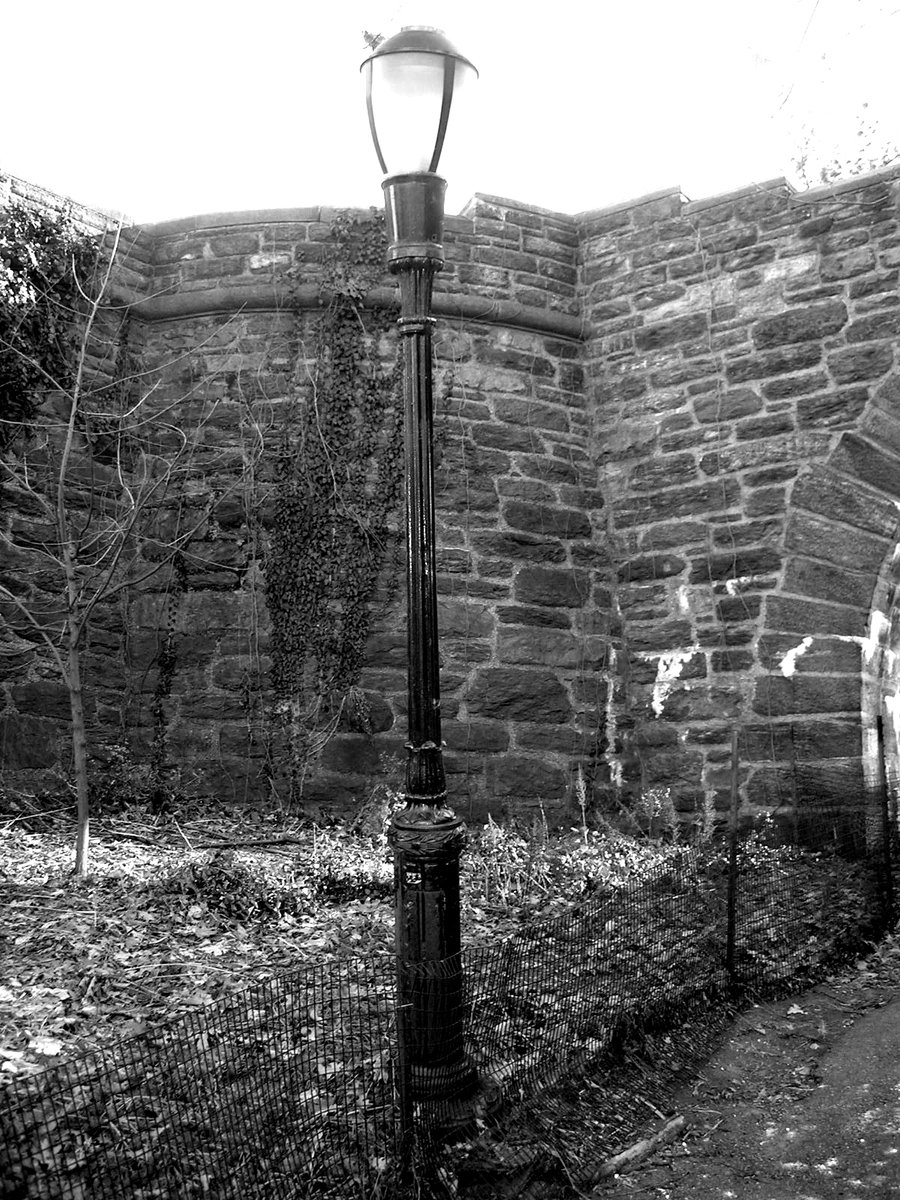 a black and white po of a lamppost in the alley