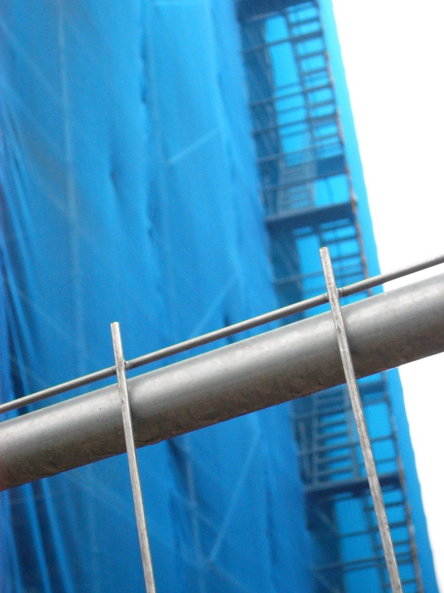 a blue building and two metal railings on top of it