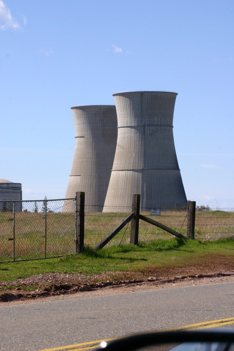 two cooling towers are seen through a car window