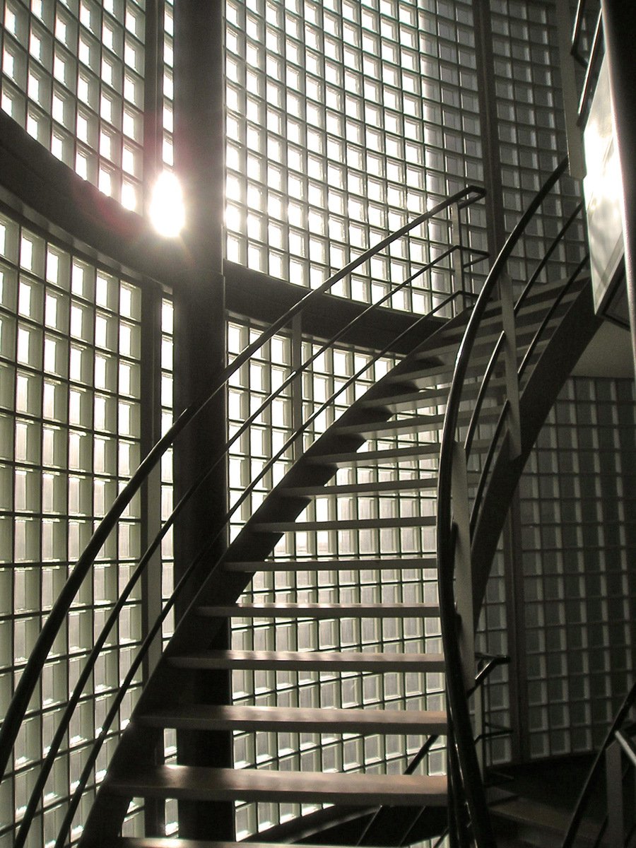 the metal stair railing has a light bulb shining through it