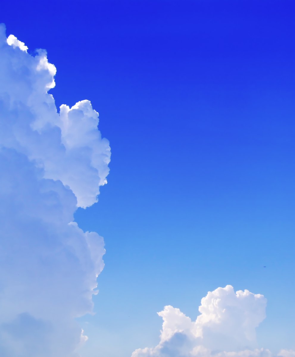 a large puffy cloud looms in a blue sky