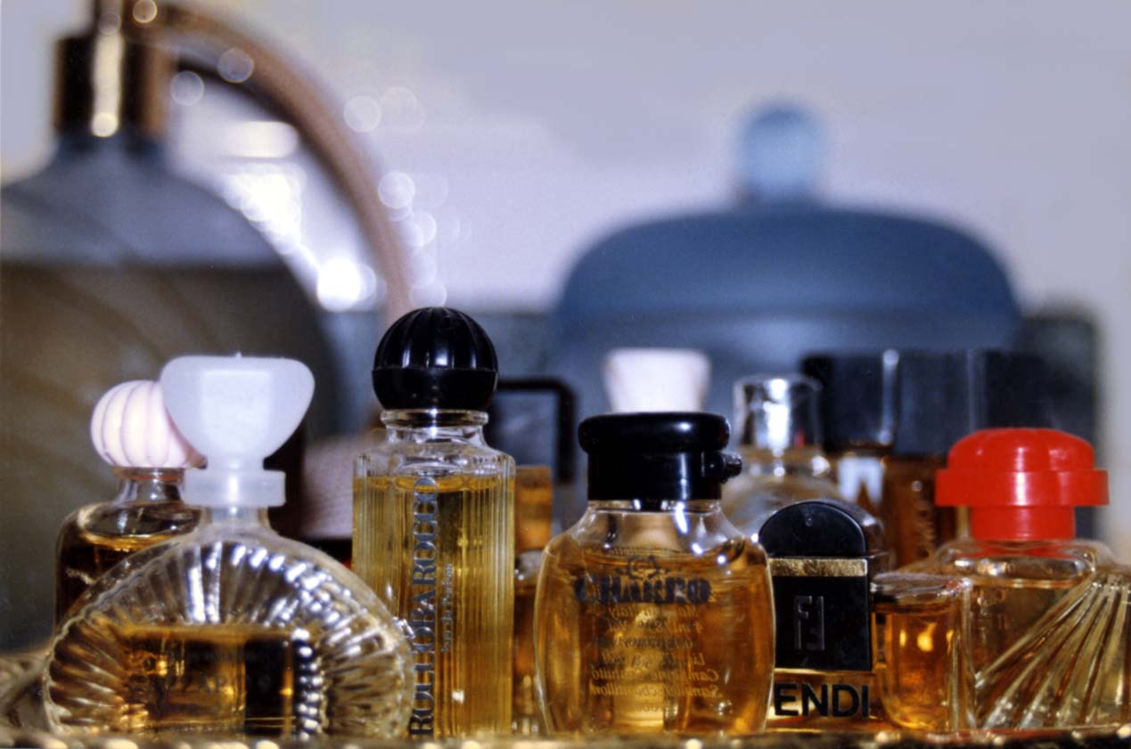 a close up of many bottles of perfume and a pitcher