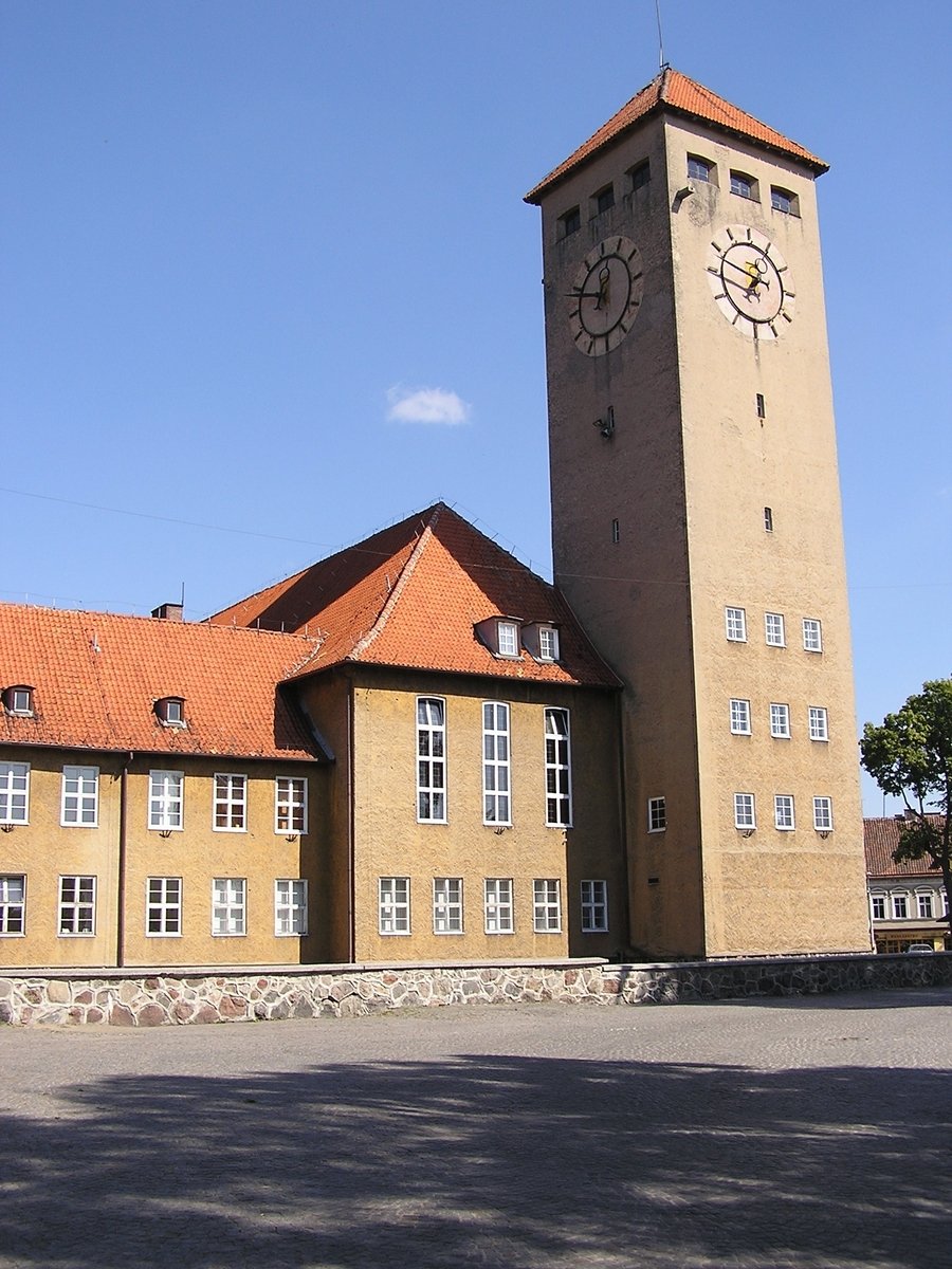 a building with a clock on the side is brown
