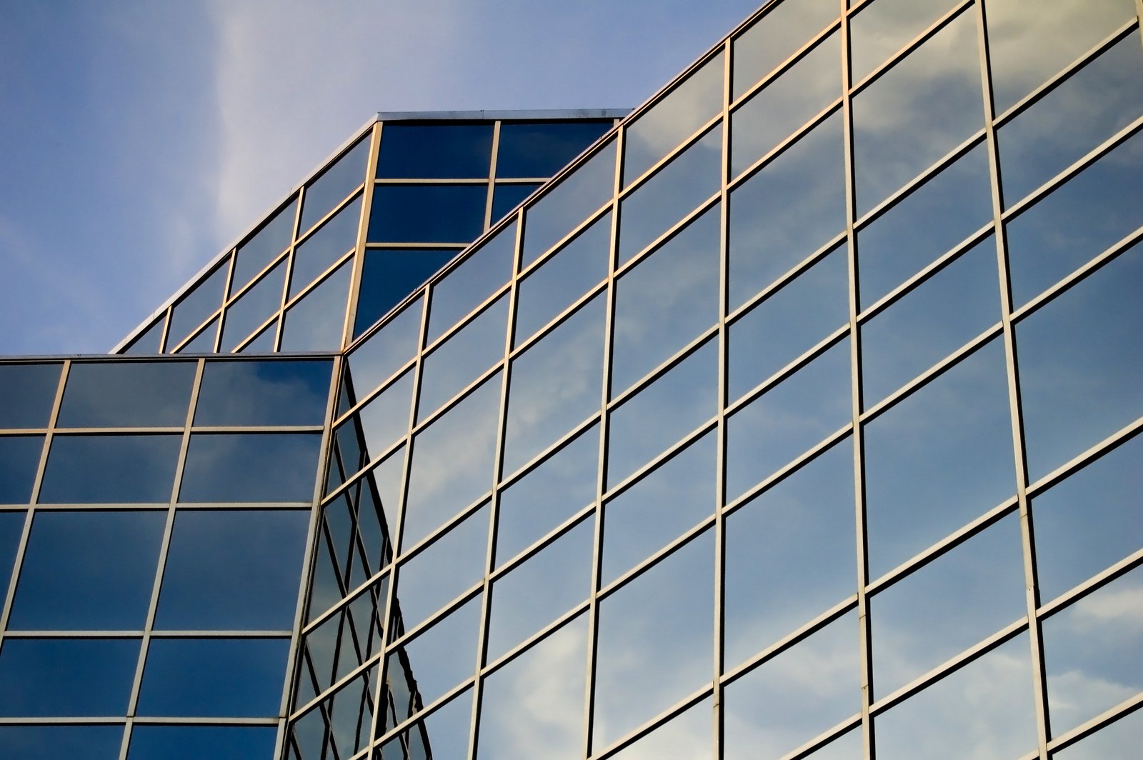 an office building with many windows and an airplane flying by