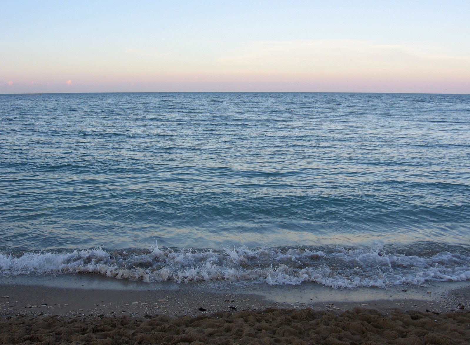 waves on an ocean beach at sunset or sunrise