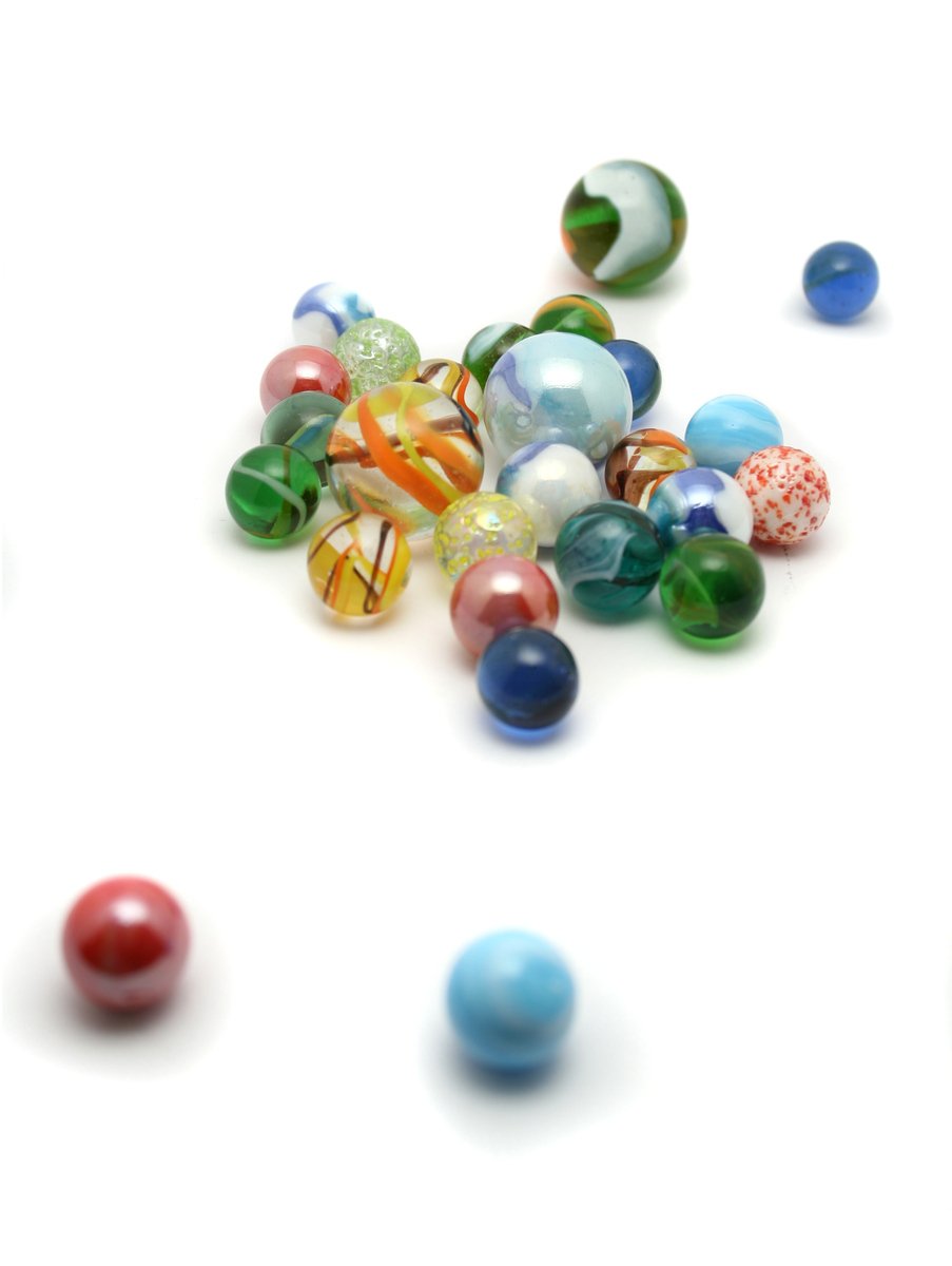 marbles falling onto the white ground while they're in motion