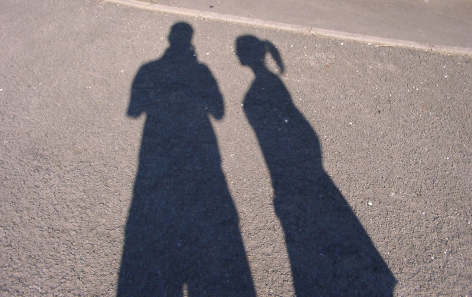 two shadows cast by one holding a skateboard