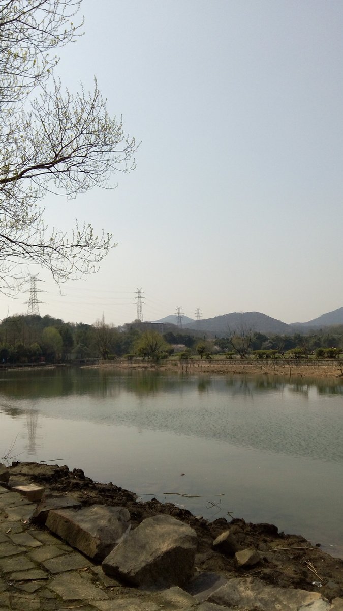 a lake near a mountain range with a clock tower in the distance