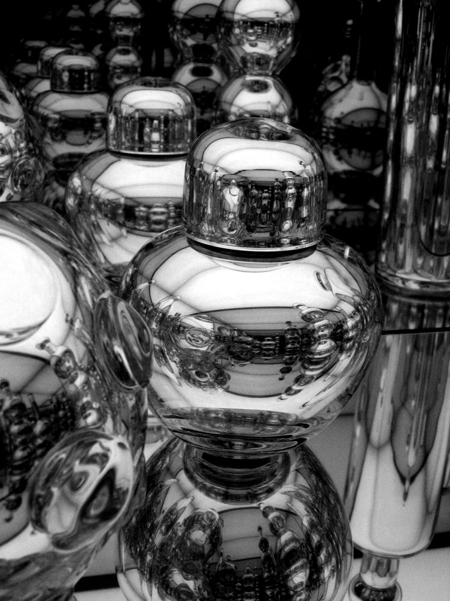 shiny crystal vases with a glass lid next to other glass
