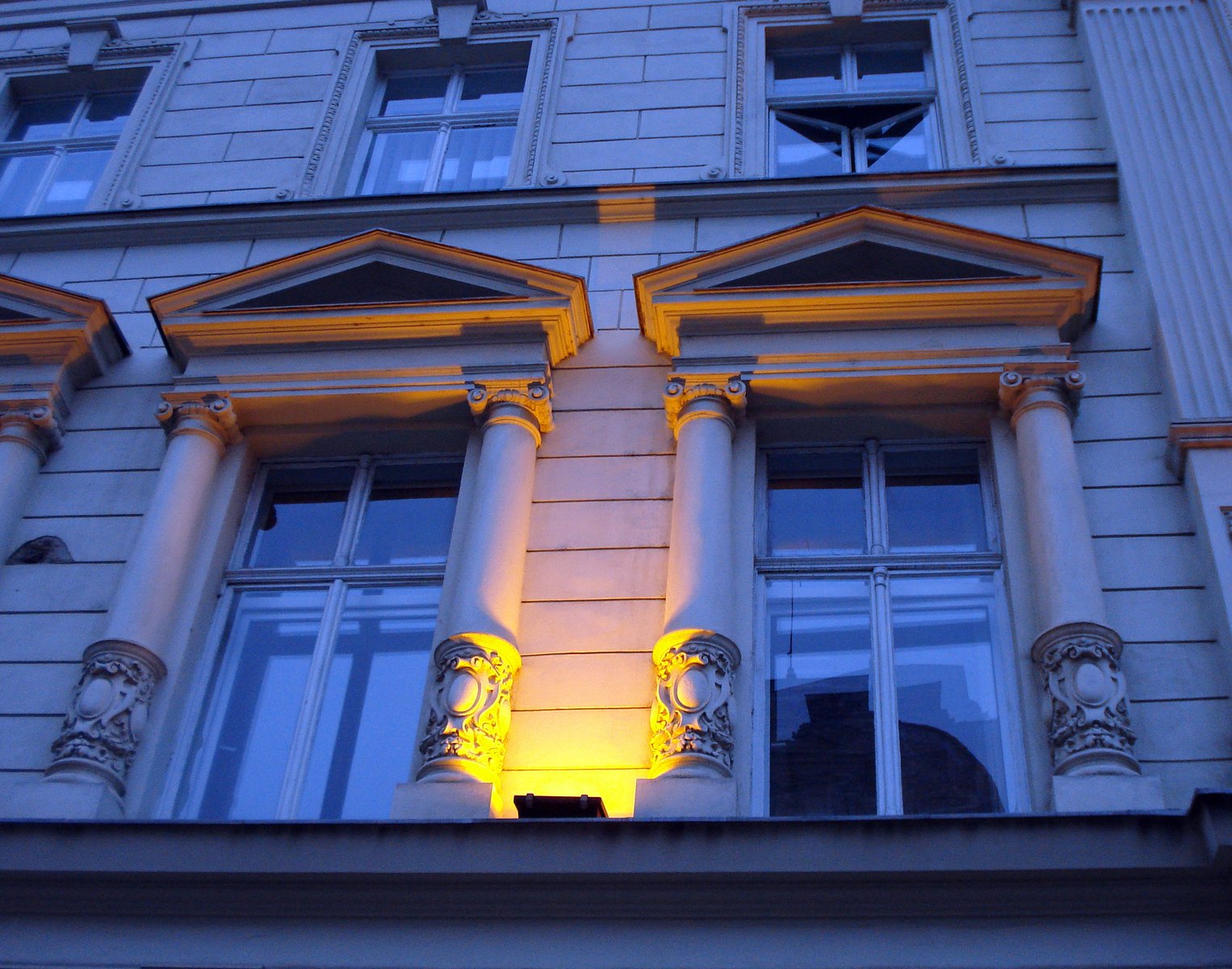 an old building with several windows lit up by the yellow light