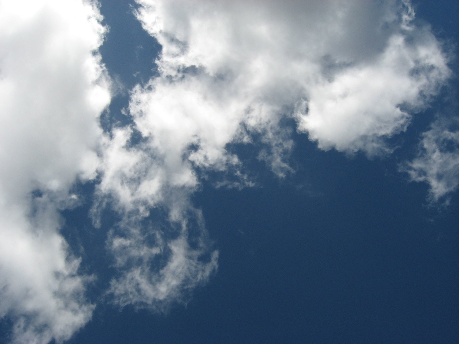 an airplane in the air with very much white clouds