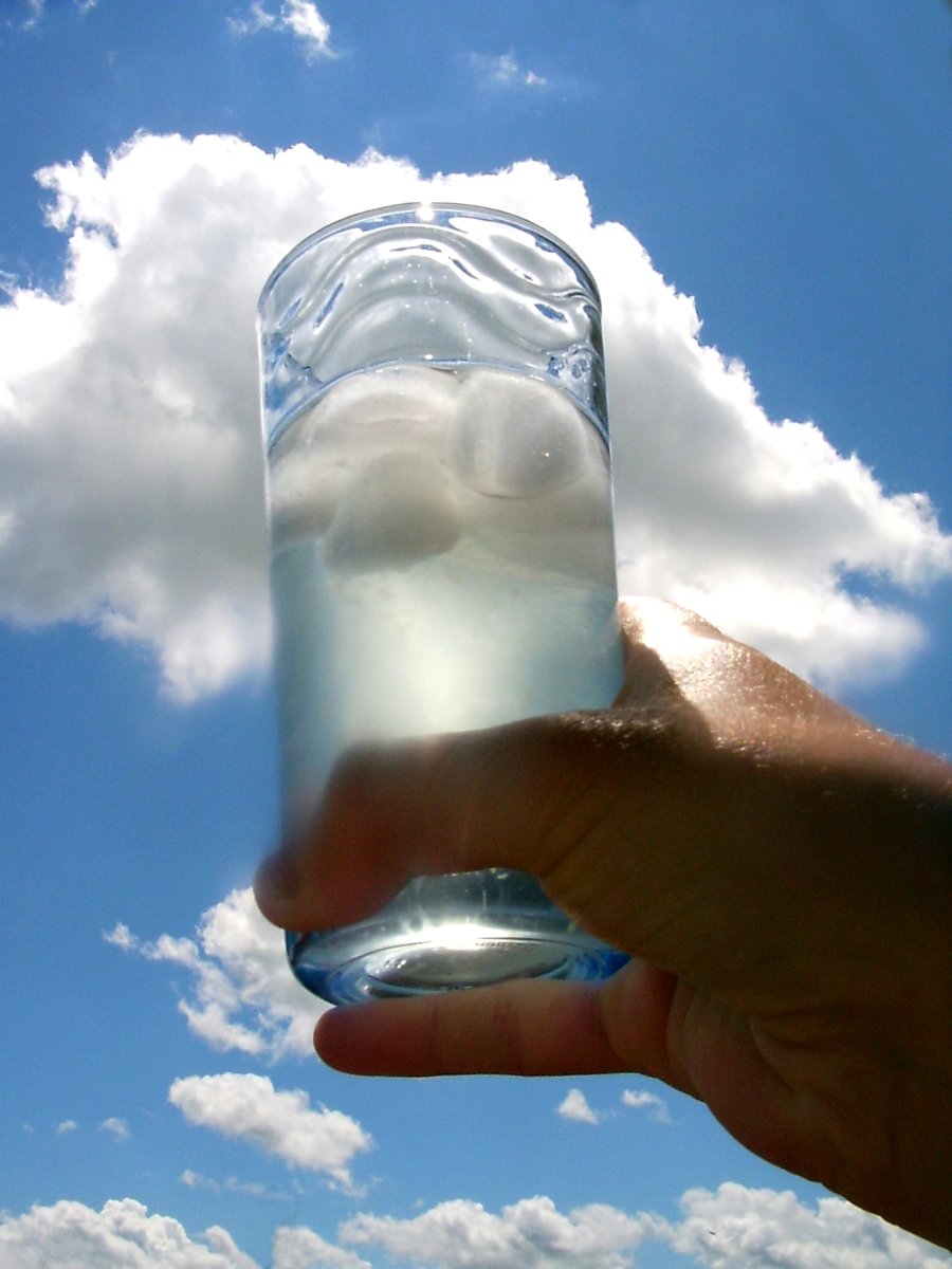 a person's hand is holding up a glass with a liquid