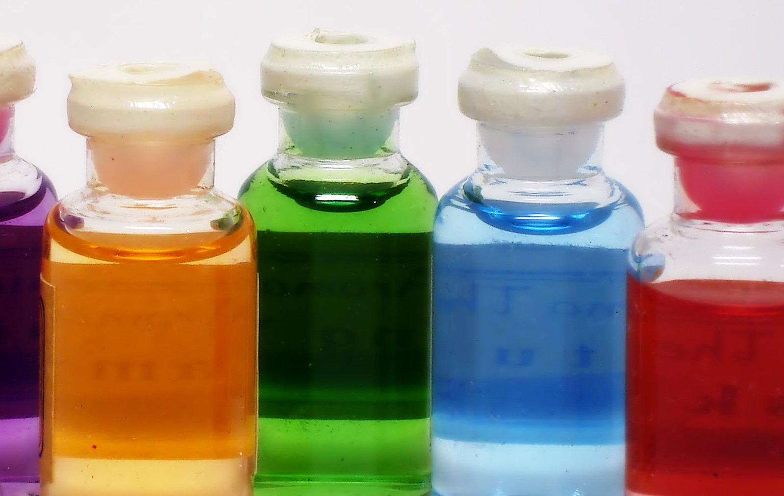 several bottles with different color options on a white surface