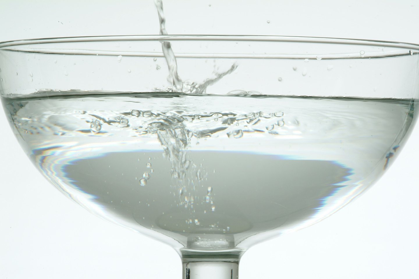 a wine glass filled with clear liquid