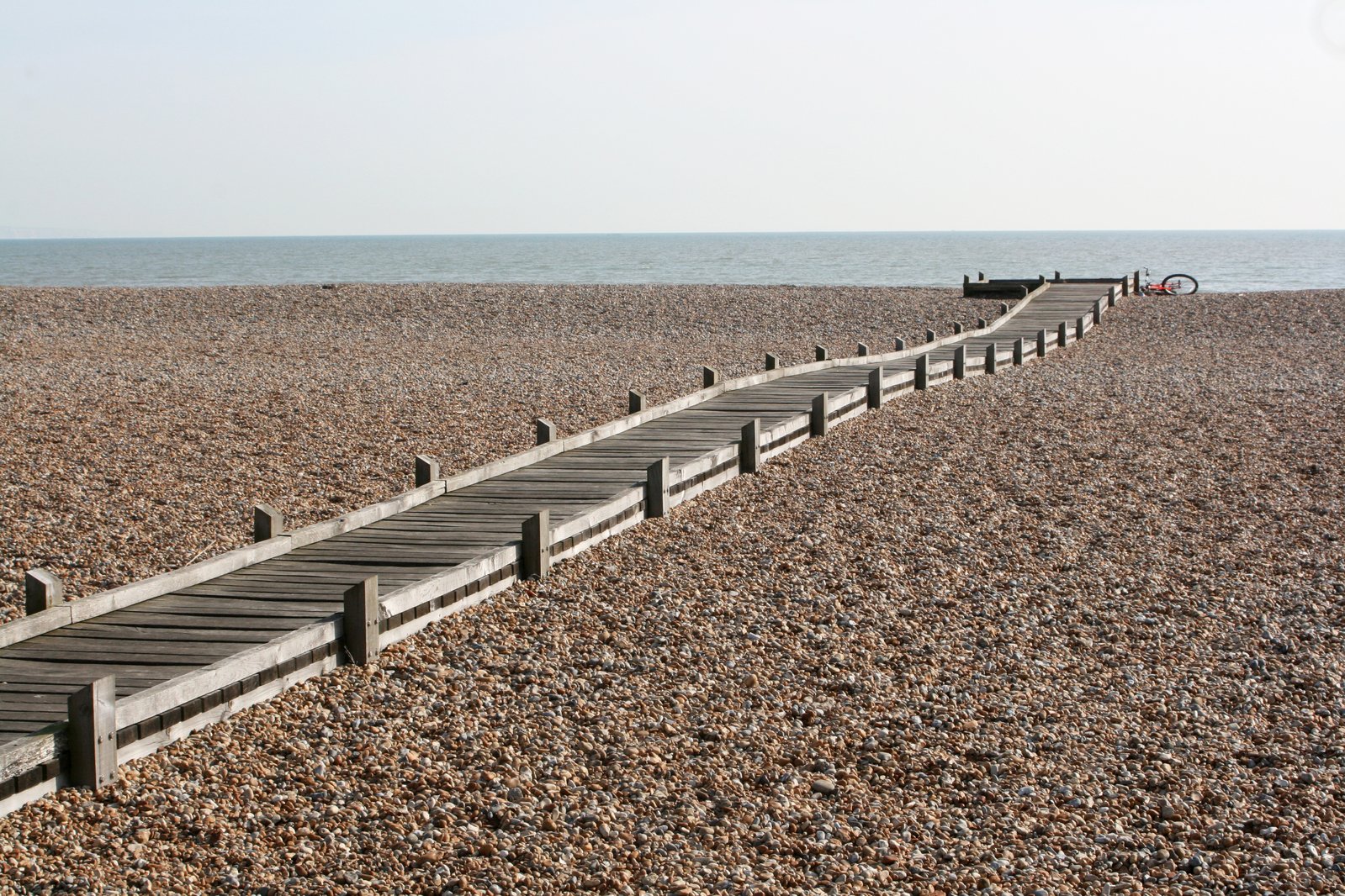 a row of benches at a park by a beach