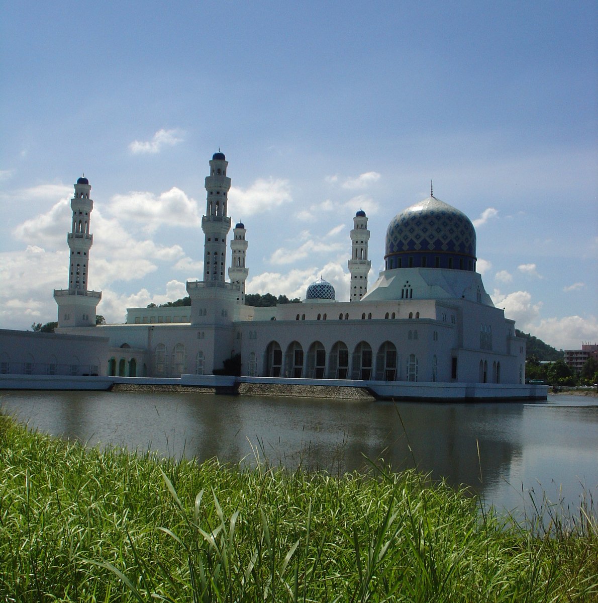 a large building with two towers next to water