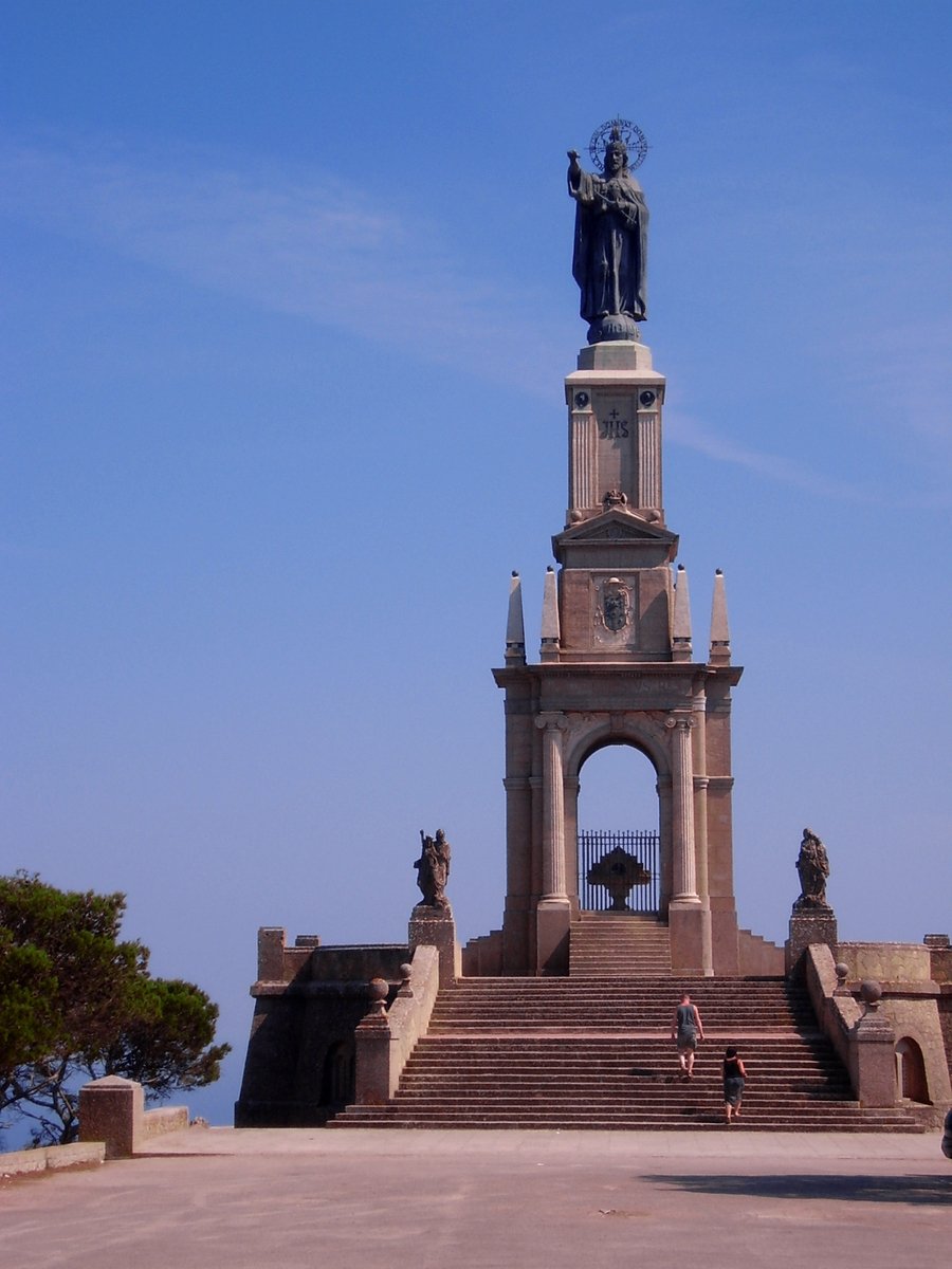 an old stone monument with people standing in front