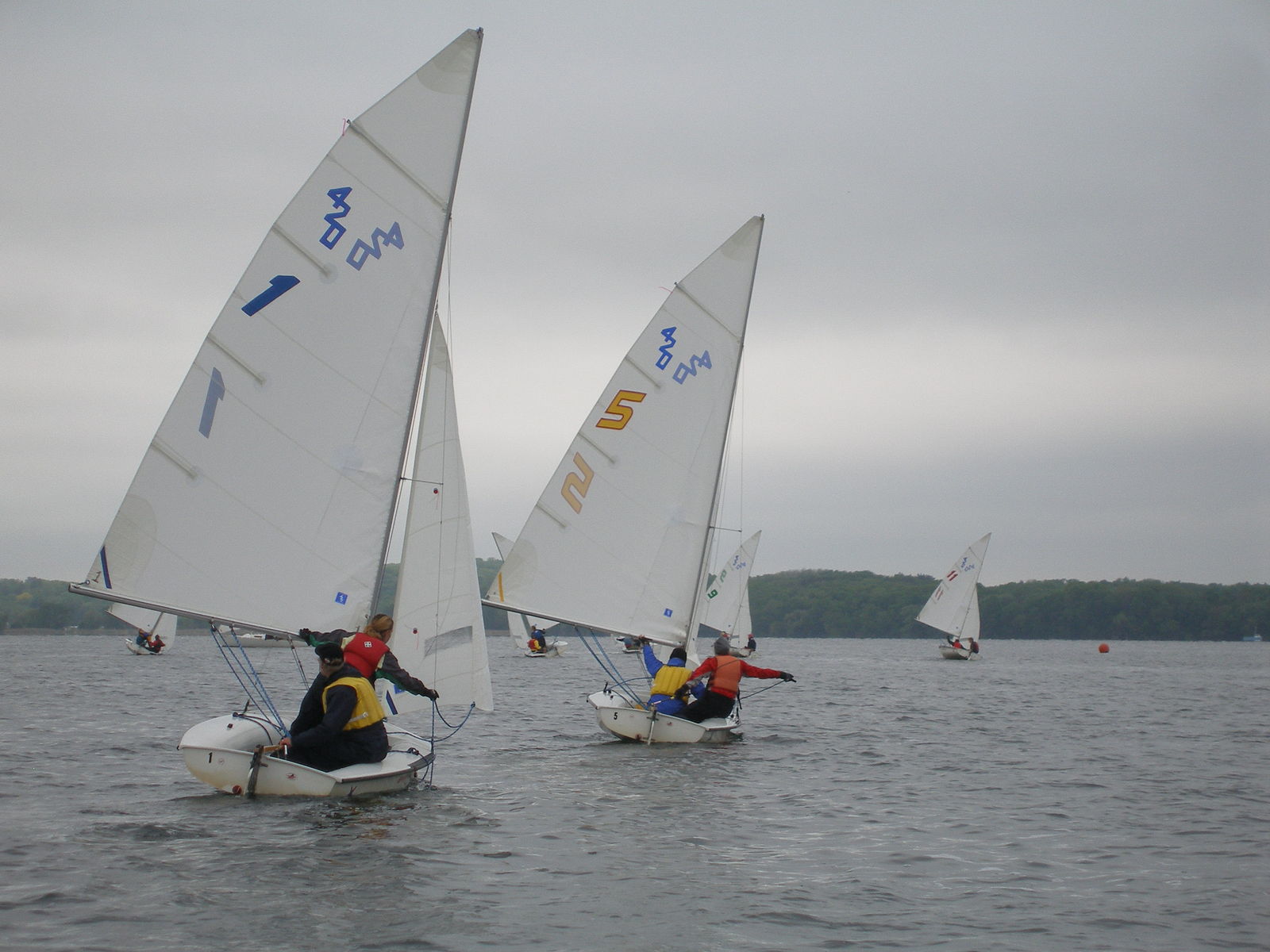 two boats with flags on the water next to each other